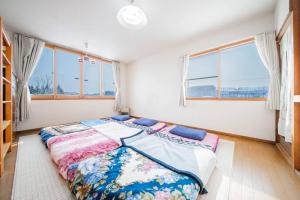 旭川市にあるGUESTHOUSE CHIYOGAOKAの窓付きのベッドルーム1室(大型ベッド1台付)