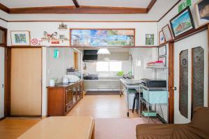 a kitchen with a table and a counter top at GUESTHOUSE CHIYOGAOKA in Asahikawa