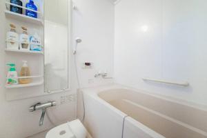 um banheiro com uma banheira branca e um vaso sanitário em GUESTHOUSE CHIYOGAOKA em Asahikawa
