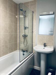 uma casa de banho com um chuveiro, um lavatório e uma banheira em Two Warehouse Apartments em Ulverston