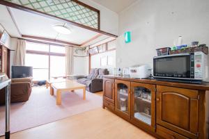 a living room with a tv and a couch at GUESTHOUSE CHIYOGAOKA in Asahikawa +81 photos