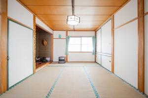 an empty room with a hallway with a window at GUESTHOUSE CHIYOGAOKA in Asahikawa