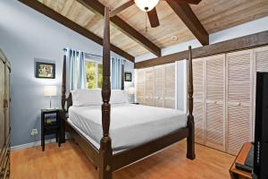 1 dormitorio con cama con dosel y techo de madera en Seabreeze Hawaii Kai en Honolulu