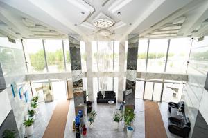 an image of a lobby with windows and plants at Reikartz Bahor Bukhara in Bukhara