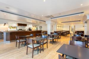 a restaurant with tables and chairs and a bar at Hotel Apartamentos Pyr Fuengirola in Fuengirola