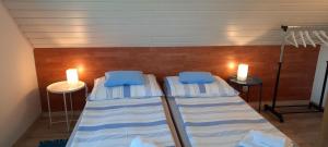two beds in a room with two lights on the wall at Kati Villa in Vonyarcvashegy +19 photos