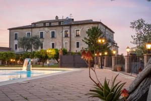 a building with a swimming pool in front of a building at Tenuta Ciminata Greco in Rossano