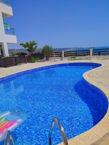 une grande piscine bleue avec des chaises en face d'un bâtiment dans l'établissement 3 Bedroom Seaview Villa direct in Coral Bay with Pool, à Coral Bay