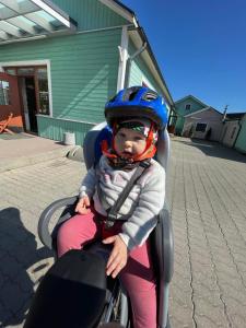 a baby wearing a helmet sitting in a stroller at Mamma maja in Haapsalu