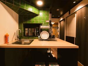 a kitchen with a sink and a green tile wall at 慶有魚·葵(Kyotofish·Himawari)*清水寺石板路旁百年町屋*网红咖啡店隔壁 in Kyoto +29 photos