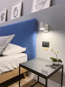 a bedroom with a blue headboard and a table at Calumidda in Catania