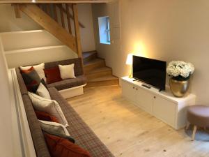 a living room with a couch and a flat screen tv at La ferme de Planchevienne in Magny-Cours