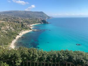 a view of a beach with blue water and trees at Villa Bella Vista in Capo Vaticano