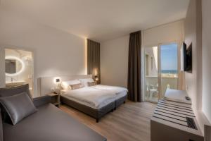 a hotel room with a bed and a balcony at Hotel Delfino in Caorle