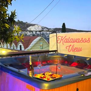 a hot tub with a bottle of wine and glasses at Kalavasos View Traditional Apartments in Kalavasos