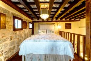 a bedroom with a large bed in a stone wall at George & Alexandra's Apartments in Rhodes Town