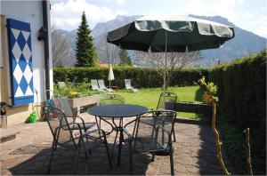 einen Tisch und Stühle mit Sonnenschirm auf einer Terrasse in der Unterkunft Hotel Weinbauer in Schwangau