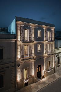un bâtiment avec des lumières sur son côté dans l'établissement Living u HomeSuites, à Lecce