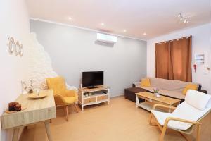 a living room with a couch and a tv at STAVROS HOUSE in Ýpsos