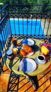 un tavolo con piatti di cibo su un balcone di Ionian Arches a Gouviá