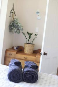 une paire de serviettes assises au-dessus d'un lit dans l'établissement Tui Ridge Cottage, à Waiterimu 46 autres photos