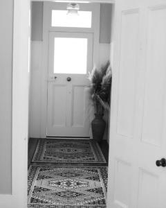 a hallway with a white door and a rug at Tui Ridge Cottage in Waiterimu