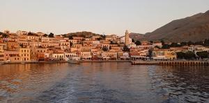 a group of houses on the shore of a body of water at Occasus Room Comfort in Halki +8 photos