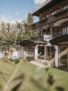 ein Haus mit einem Zaun davor in der Unterkunft VAYA Seefeld in Seefeld in Tirol