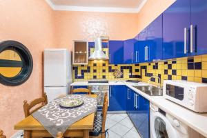a kitchen with blue cabinets and a table and a sink at Corte dei Mori in Avola