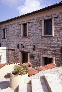 a stone building with some plants in front of it at Riserva Privata San Settimio in Arcevia