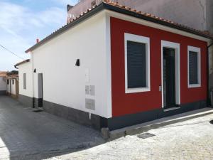 a red and white building on the side of a street at Casa da Escola in Cacia