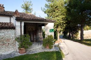 una pequeña casa de piedra con sillas y una calle en Riserva Privata San Settimio, en Arcevia