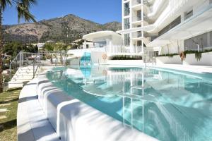 a swimming pool in front of a building at HigueronRentals Hill Manon in Benalmádena