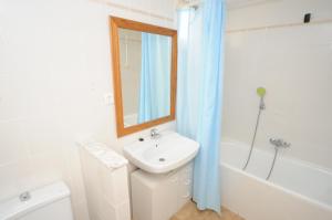 a white bathroom with a sink and a bath tub at Adosado Puntamer Orangecosta in Peñíscola +13 photos