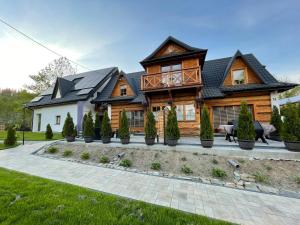 a log home with a black roof at Apartamenty rodzinne,NOWE !!! wakacje 2024!! wycieczka rowerowa gratis!!! in Biały Dunajec