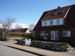 uma casa com uma cerca branca em frente em Enjoy-Sylt-1 em Westerland