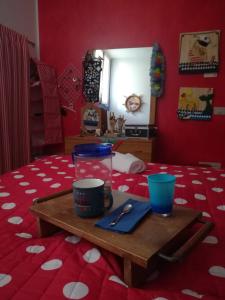 uma mesa num quarto com uma cama com paredes vermelhas em Sea and Relax in an artist house em Muravera