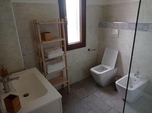 uma casa de banho com um WC e um lavatório em B&B da Rosella em Lotzorai