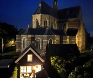 eine Kirche in der Nacht mit Lichtern im Fenster in der Unterkunft B&B De Nicolaas in Brouwershaven