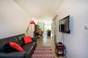 ein Wohnzimmer mit einem Sofa und einem Flachbild-TV in der Unterkunft Le Pop in Saint-Julien-Chapteuil