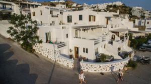 2 personnes marchant devant une maison blanche dans l'établissement Villa Elina suites and more, à Agios Stefanos