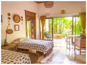 a bedroom with two beds and a sliding glass door at Sriyana Uluwatu in Uluwatu