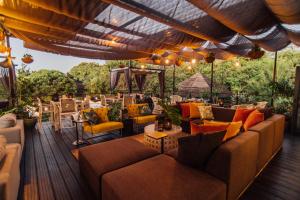 un patio esterno con divani, tavoli e sedie di Thaba Eco Hotel a Johannesburg
