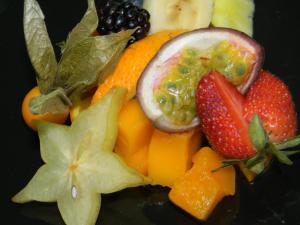 un cumulo di frutta su un piatto nero di Hotel Pulicinu a Baja Sardinia