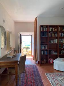a living room with a desk and a book shelf at Il Montelletto in Santa Luce