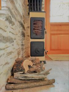 a wood stove in a room with a wall at Konaki Hikers Lodge by Andros Routes in Andros