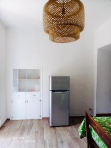 uma cozinha com um frigorífico de aço inoxidável e um lustre em Villa Franca Nature Holidays em Rezzo