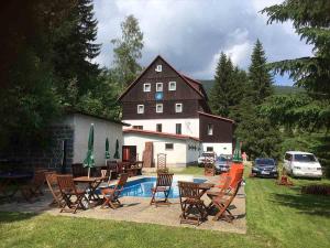 une grande maison avec une table et des chaises ainsi qu'une piscine dans l'établissement Hotel Flora Dolní Mísečky, à Dolni Misecky