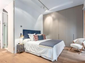 a bedroom with a large bed and a chair at City Center modern apartment for 4 SANTA TERESA II in Madrid