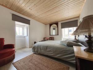 ein Schlafzimmer mit einem großen Bett und einer Holzdecke in der Unterkunft Julia Old Village by Lisbon Village Apartments in Terrugem